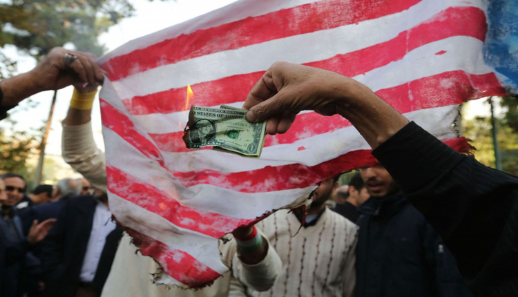 متظاهرون إيرانيون يحرقون العلم و العملة الأمريكية