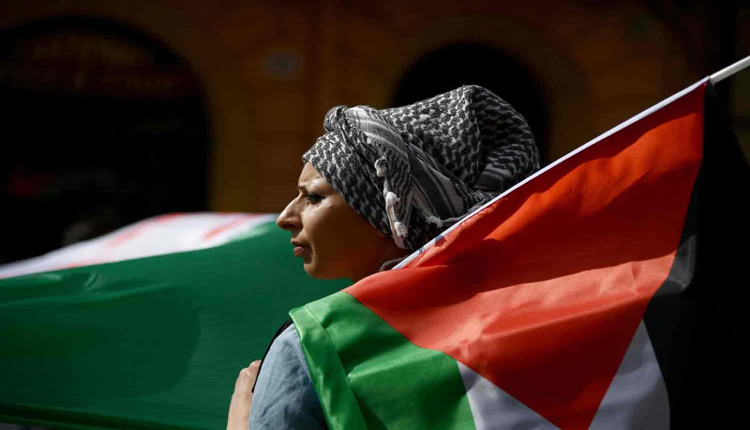 فلسطينية تحمل راية بلاده