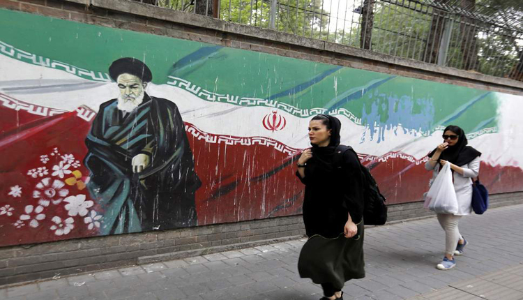 مواطنة إيرانية تتمشى أمام جدارية لخميني