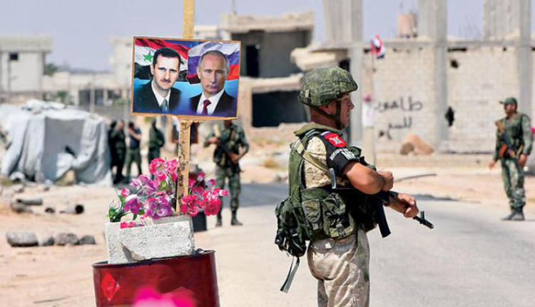 عناصر من الشرطة الروسية قرب صورتين لبوتين والاسد في غوطة دمشق 