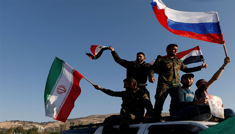 قوات عسكرية ترفع أعلام روسيا، سوريا وإيران