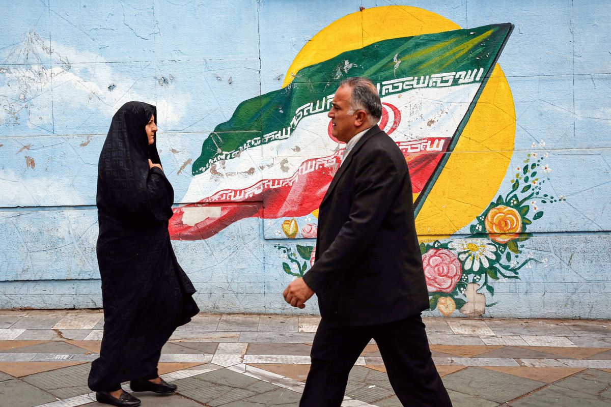 إيرانيون أمام جدارية في طهران