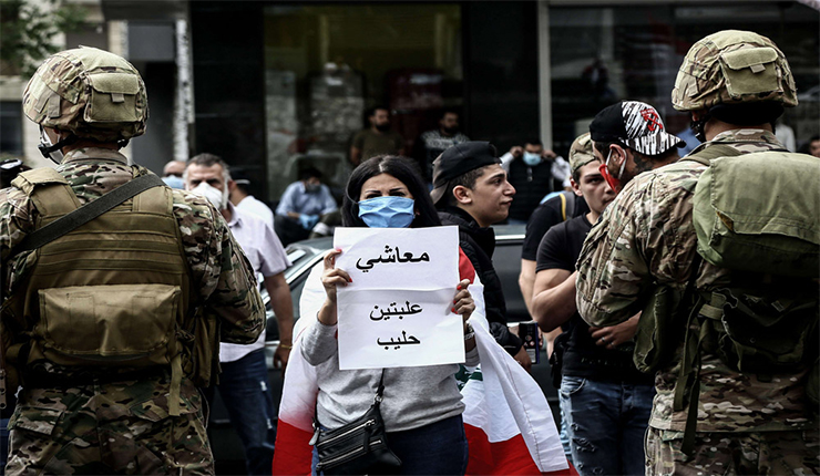 متظاهرة لبنانية ترفع لافتة ضد الحكومة