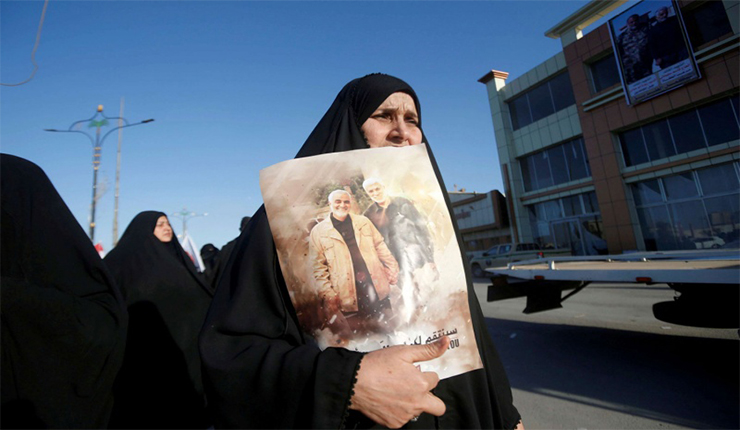امرأة تحمل صورة سليماني والمهندس