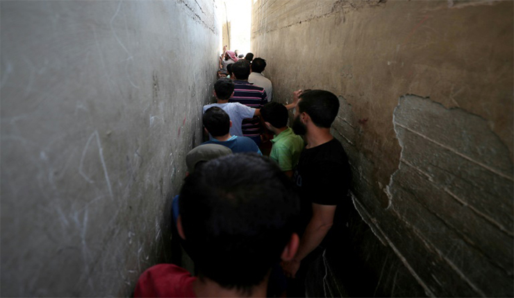 سوريون يقفون بالصف لشراء الخبز في محل في مدينة بنش في شمال غرب سوريا (فرانس بريس)