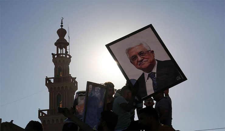 فلسطينيون يرفعون صورة محمود عباس، رئيس السلطة الفلسطينية