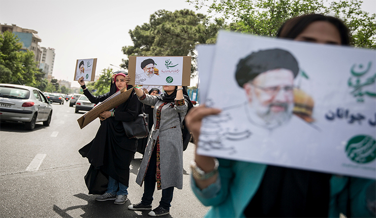 إيرانيون يحملون صورة رئيسي