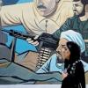 إيرانية تمر بجانب جدارية في طهران