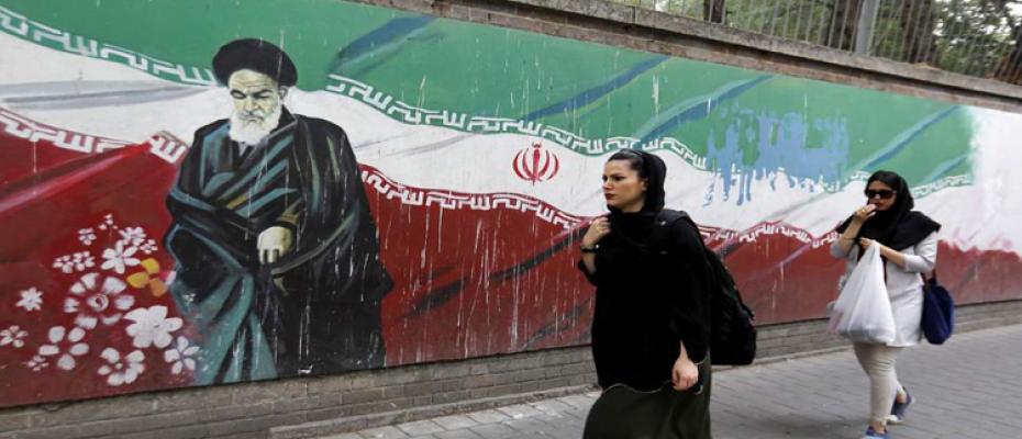 مواطنة إيرانية تتمشى أمام جدارية لخميني