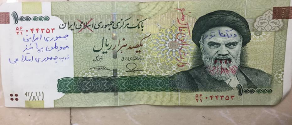 تخريب العملة الإيرانية وصور الخميني