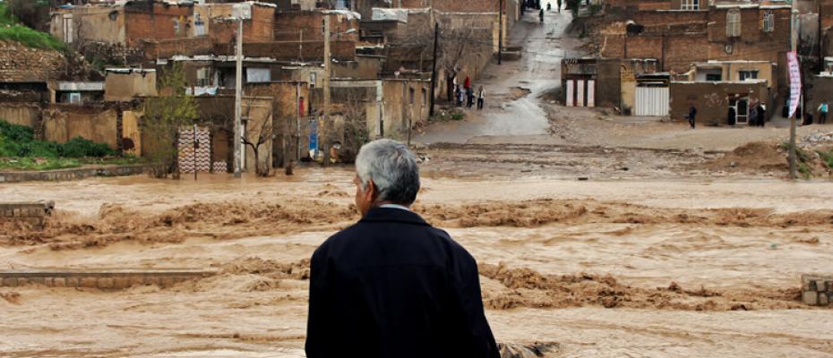 مواطن إيراني واقف أمام السيول 