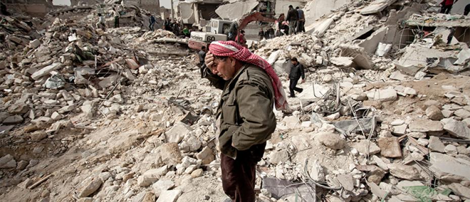 سوري يقف على بقايا منزله بعد دماره
